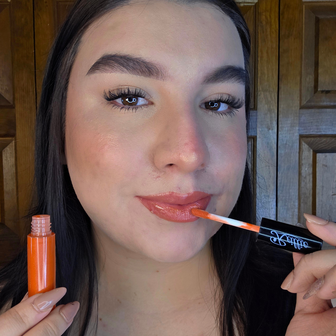 Woman with fair skin wearing Reillie Beauty Organic Lip Gloss in Cinnamon, warm orange shimmering shade with nourishing botanicals