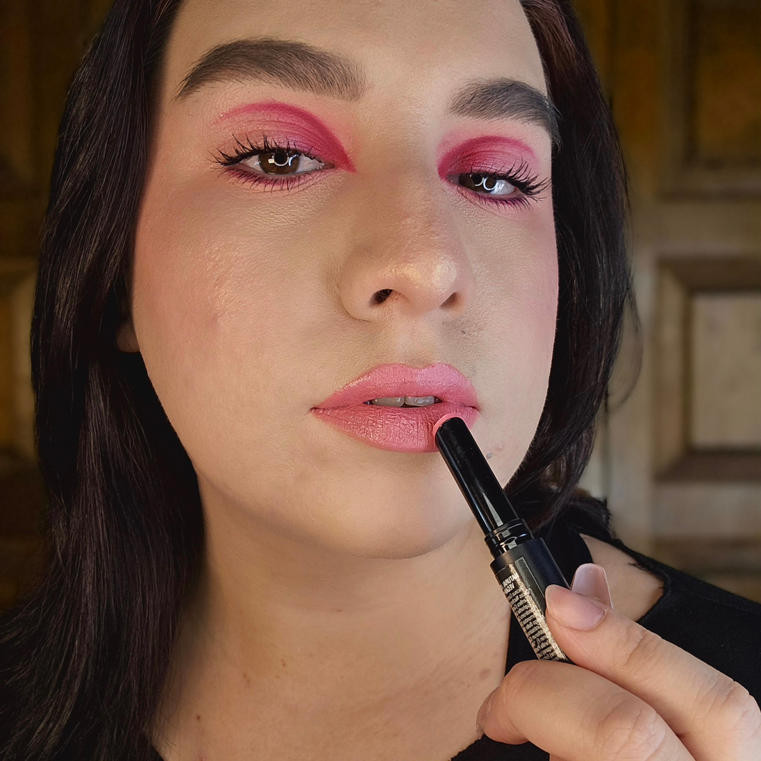 oman with fair skin applying Reillie Beauty Organic Lipstick in Peony, bright pink shade with nourishing botanicals