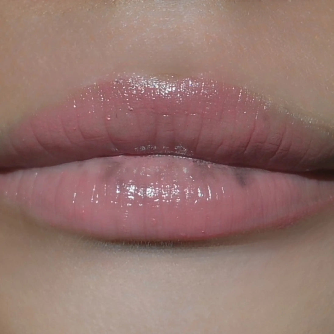Woman with medium skin wearing Berry glow Gloss not shimmering shade with nourishing botanicals