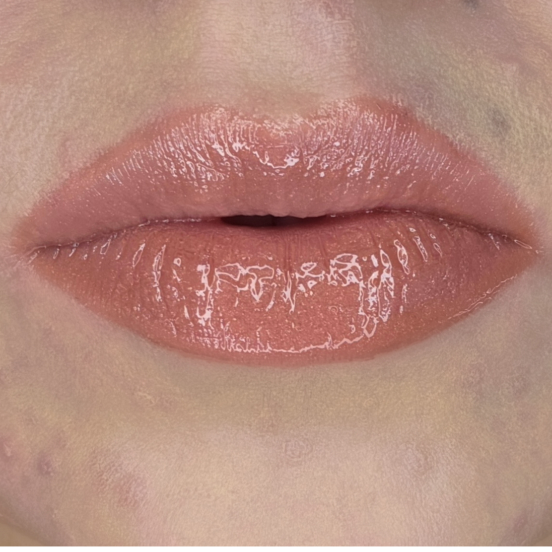 Woman with fair skin wearing Caramel Lip Gloss, clear shimmering shade with nourishing botanicals