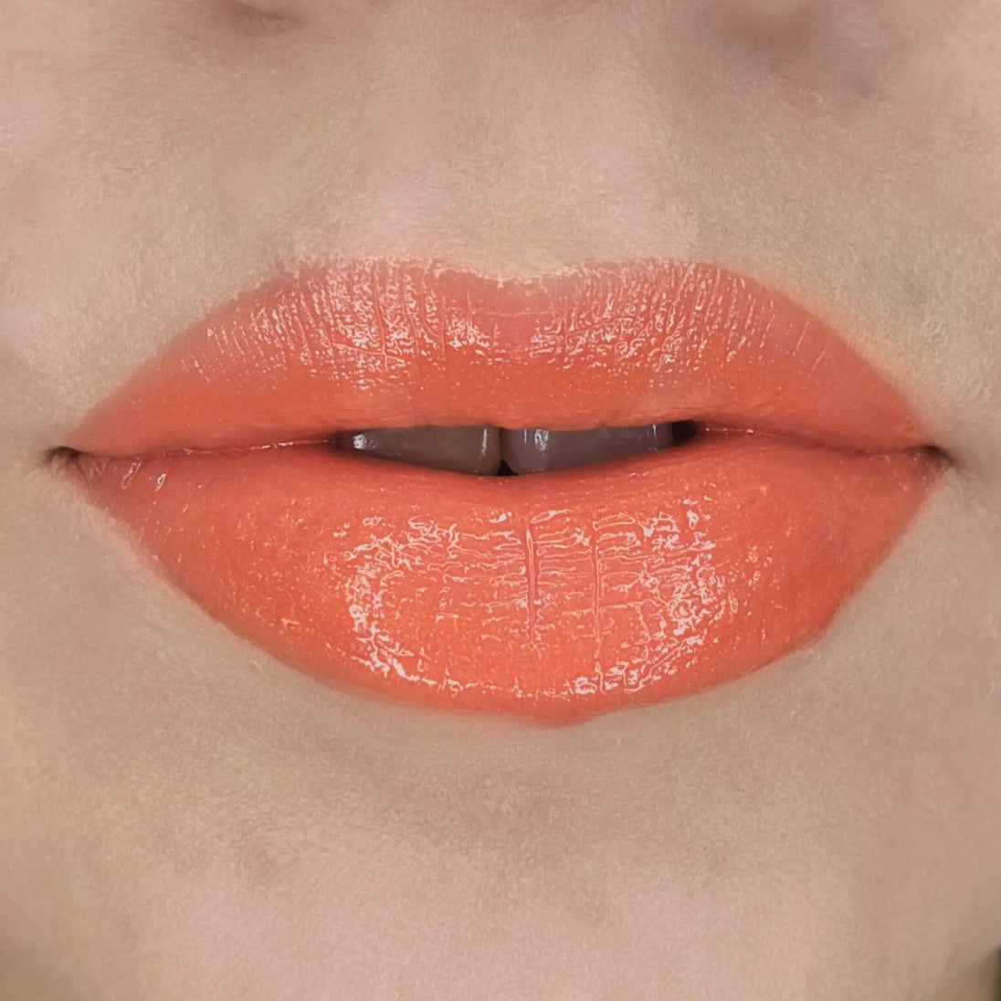Woman with fair skin wearing Cinnamon Lip Gloss, clear shimmering shade with nourishing botanicals