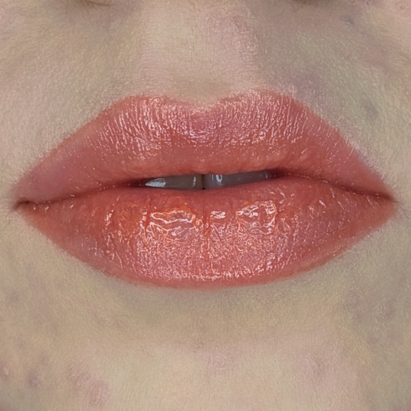 Woman with fair skin wearing Cinnamon Lip Gloss, clear shimmering shade with nourishing botanicals