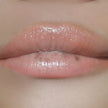 Woman with medium skin wearing cinnamon Lip Gloss, clear shimmering shade with nourishing botanicals