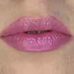 Woman with fair skin wearing Dragon Fruit Lip Gloss, clear shimmering shade with nourishing botanicals.