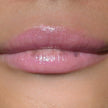 Woman with medium skin wearing Dragon fruit Gloss, clear shimmering shade with nourishing botanicals