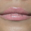 Woman with medium skin wearing Guava Lip Gloss not shimmering color shade with nourishing botanicals