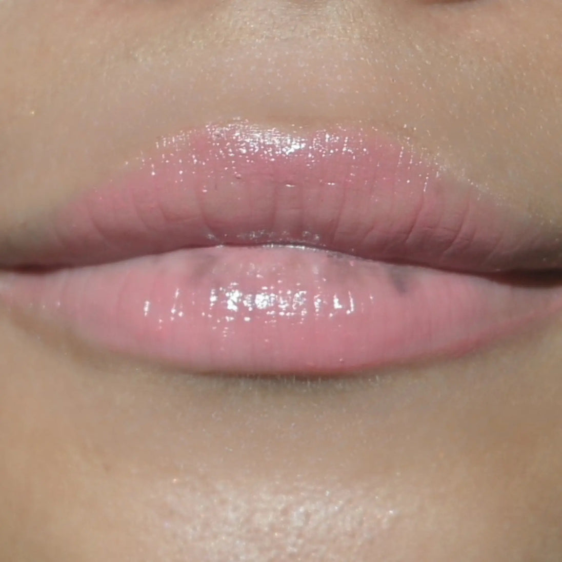 Woman with medium skin wearing Guava Lip Gloss not shimmering color shade with nourishing botanicals