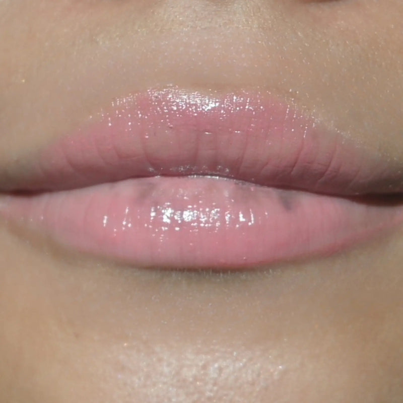 Woman with medium skin wearing Guava Lip Gloss not shimmering color shade with nourishing botanicals