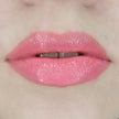 Woman with fair skin wearing luscious guava Lip Gloss, clear shimmering shade with nourishing botanicals