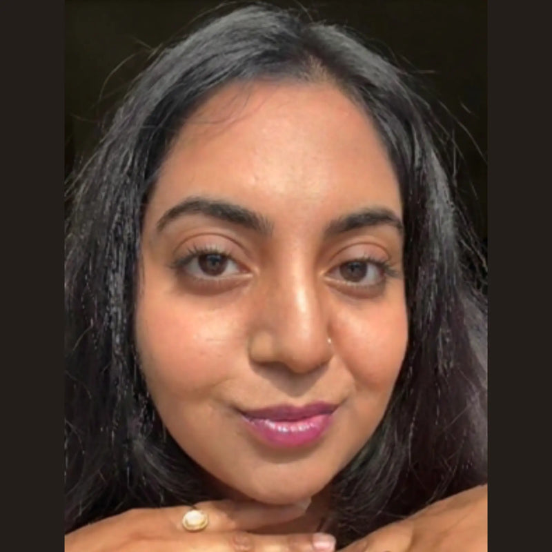 A close-up of a woman wearing comfort lip gloss shade dragon fruit and soft lift mascara.