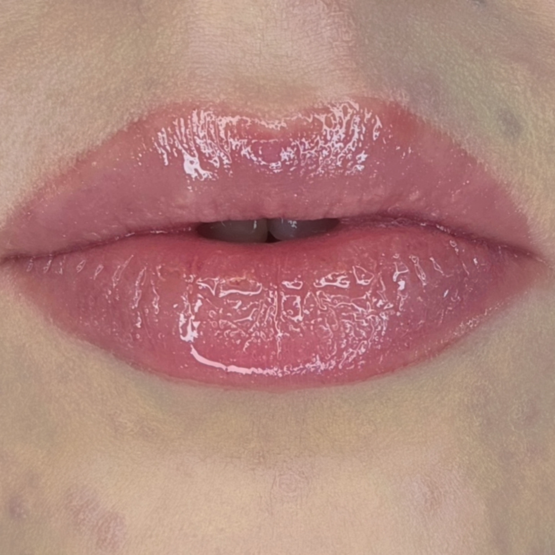 Woman with fair skin wearing Sugar Veil Lip Gloss, clear shimmering shade with nourishing botanicals