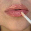 Woman with medium skin wearing Sugar veil Gloss, clear shade with nourishing botanicals