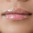 Woman with medium skin wearing Sugar veil Gloss, clear shade with nourishing botanicals