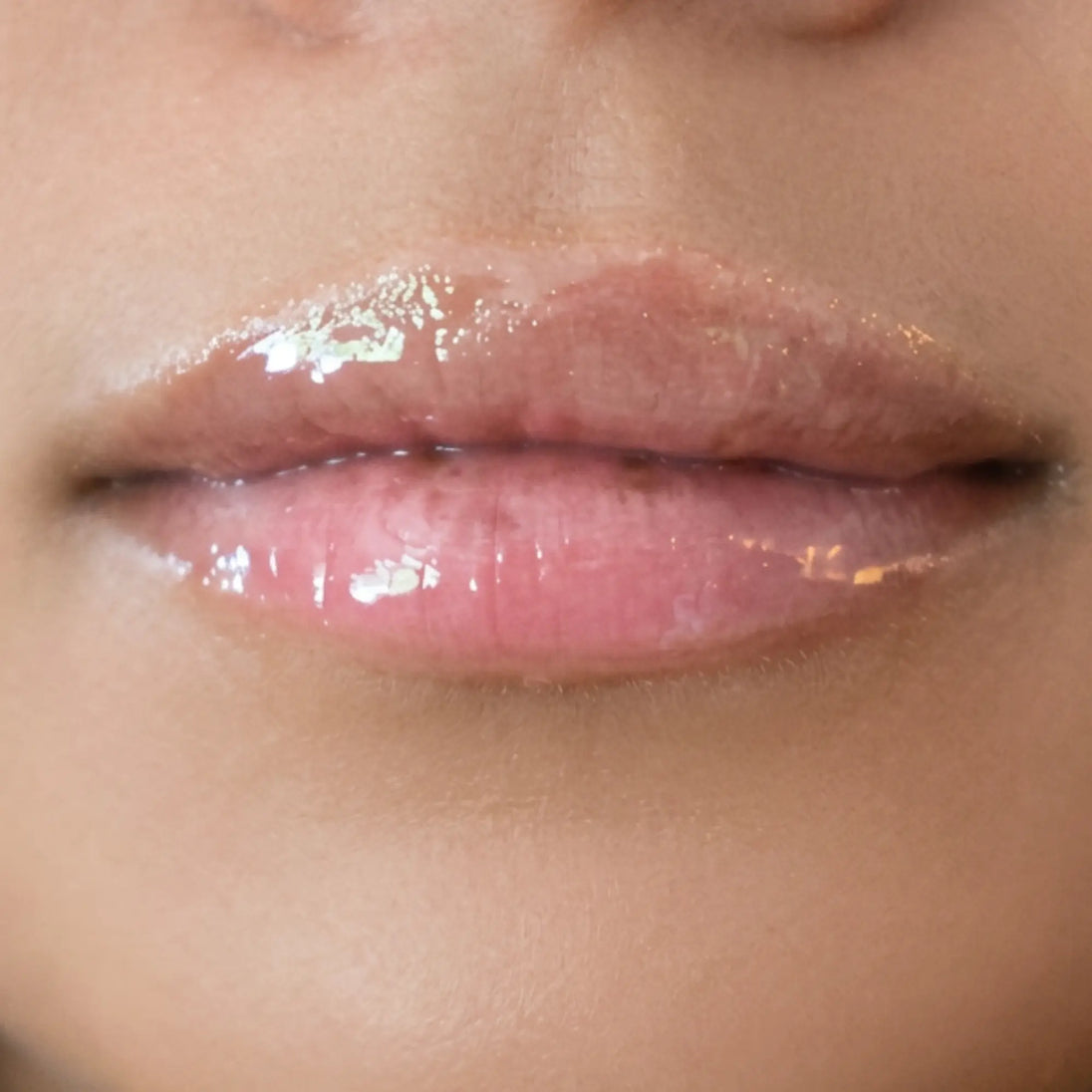 Woman with medium skin wearing Sugar veil Gloss, clear shade with nourishing botanicals
