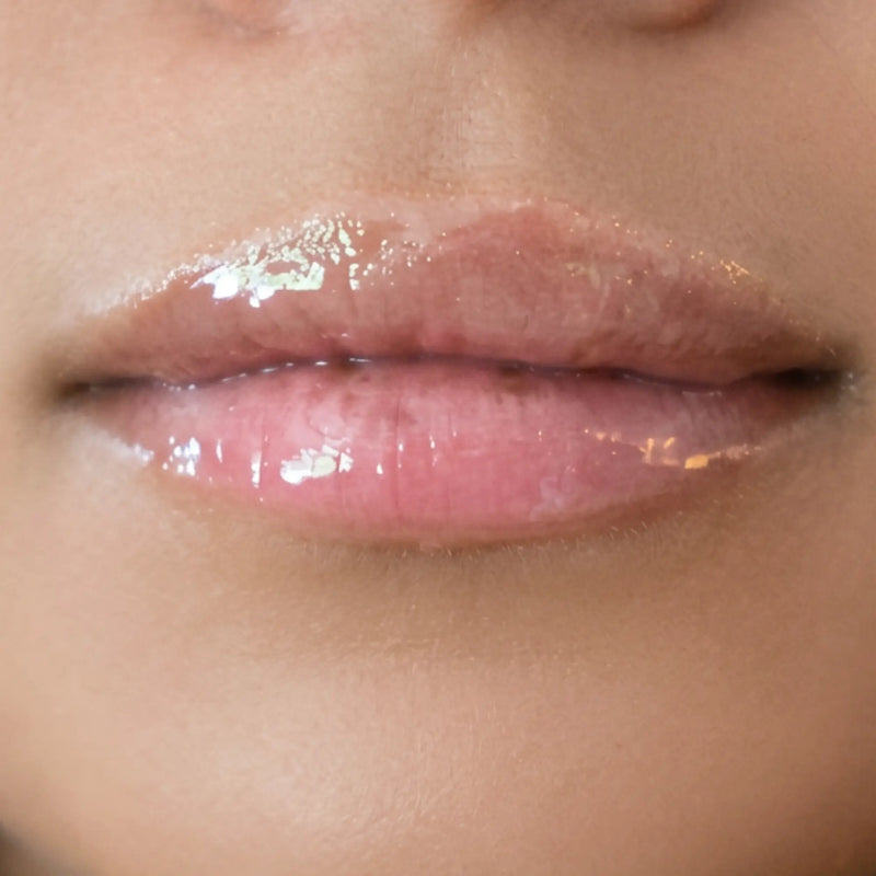 Woman with medium skin wearing Sugar veil Gloss, clear shade with nourishing botanicals