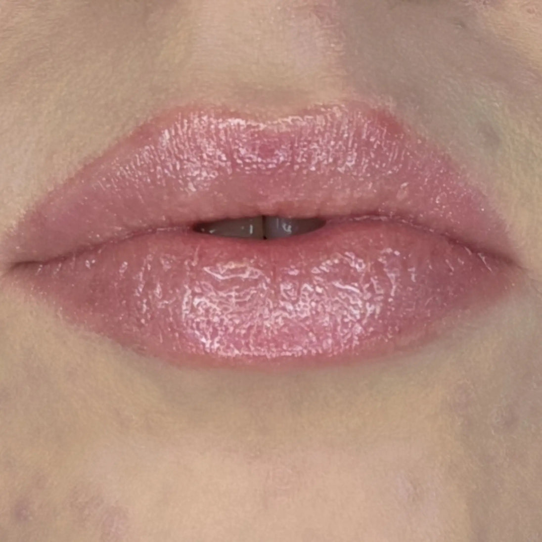 Woman with fair skin wearing Creamy Vanilla Lip Gloss, clear shimmering shade with nourishing botanicals
