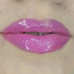 Woman with fair skin wearing Dragon fruit Gloss, clear shimmering shade with nourishing botanicals