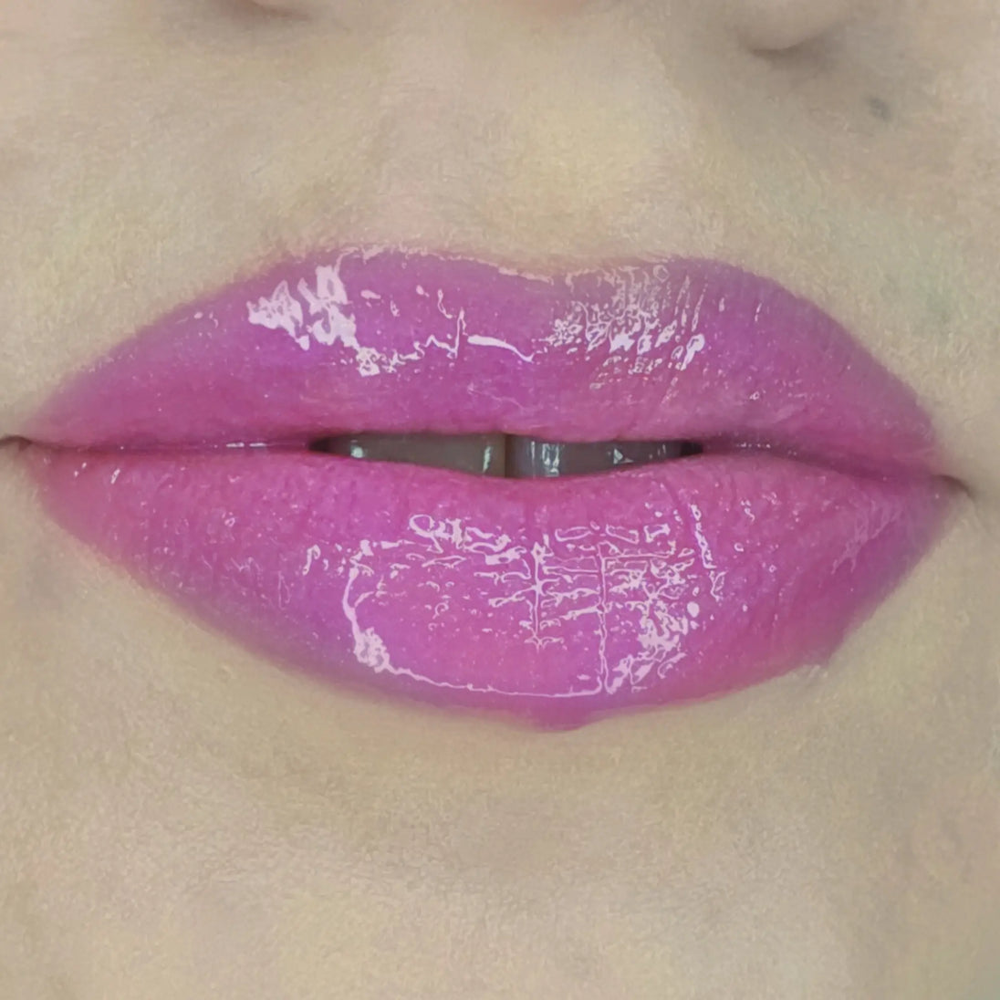 Woman with fair skin wearing Dragon fruit Gloss, clear shimmering shade with nourishing botanicals
