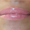 Woman with medium skin wearing luscious guava Lip Gloss, clear shade with nourishing botanicals