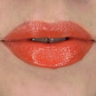 Woman with fair skin wearing Cinnamon Lip Gloss, clear shimmering shade with nourishing botanicals