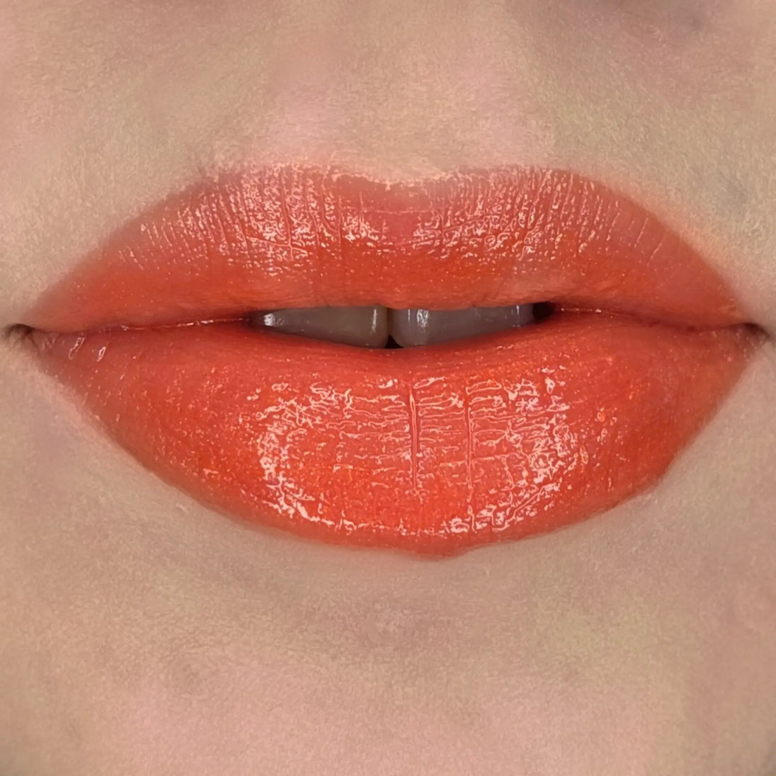 Woman with fair skin wearing Cinnamon Lip Gloss, clear shimmering shade with nourishing botanicals