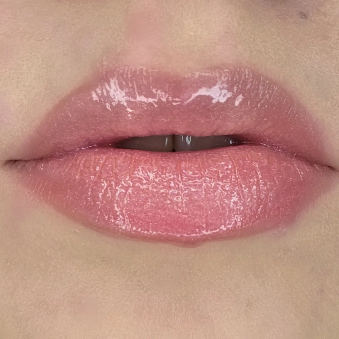 Woman with fair skin wearing Creamy Vanilla Lip Gloss, clear shimmering shade with nourishing botanicals