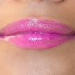 Woman with medium skin wearing Dragon fruit Gloss, clear shimmering shade with nourishing botanicals