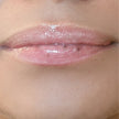 Woman with medium skin wearing Creamy Vanilla Lip Gloss, clear shimmering shade with nourishing botanicals